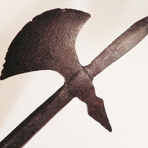 May include: A rusty metal weapon with a long, pointed blade and a curved axe head.