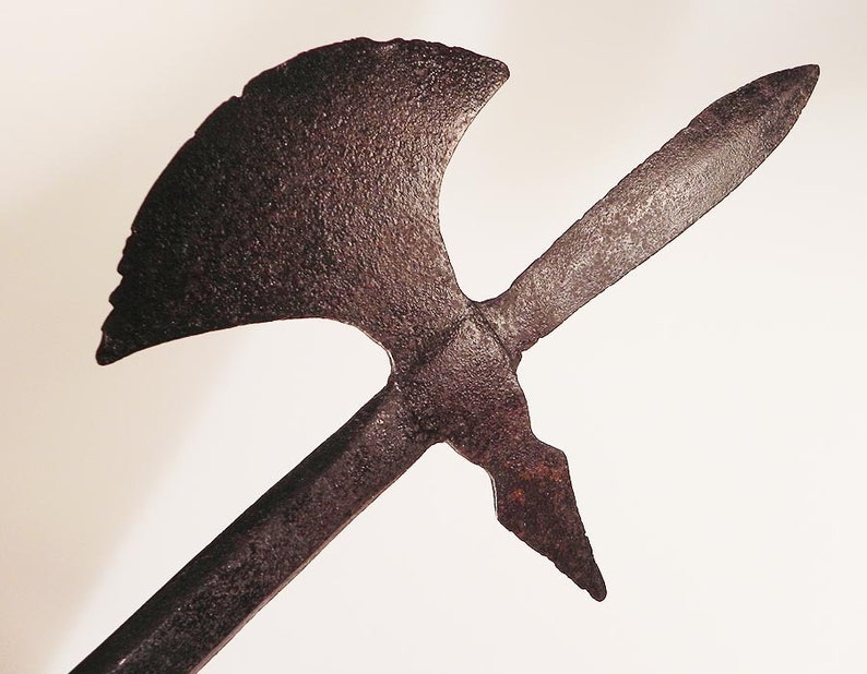 May include: A rusty metal weapon with a long, pointed blade and a curved axe head.