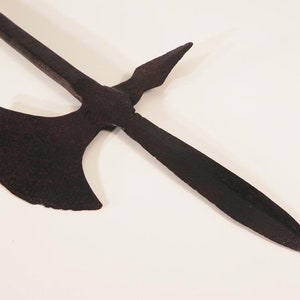 May include: A black metal weapon with a long, pointed blade and a crescent-shaped axe head. The weapon is made of iron and has a rustic, aged appearance.