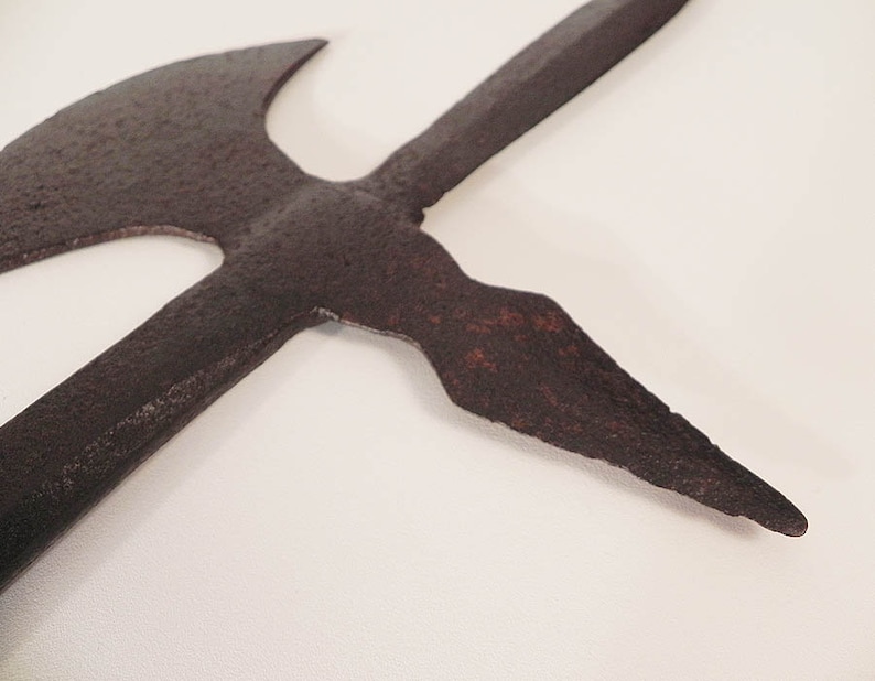 May include: A rusty, medieval-style weapon with a double-headed axe and a spear point. The weapon is made of metal and has a dark brown color.