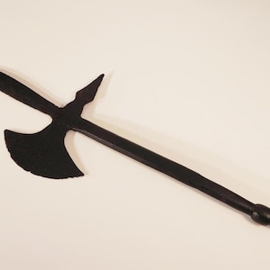 May include: A black metal axe with a long handle and a pointed tip. The axe head has a curved blade and a small spike on the back.