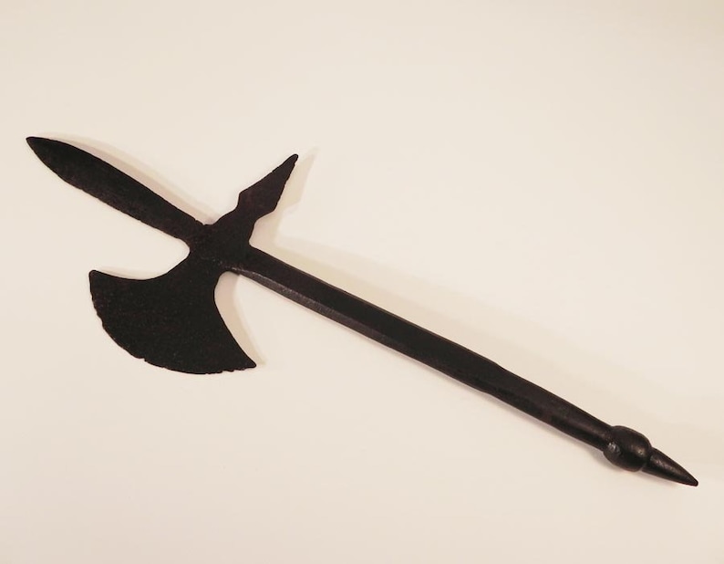 May include: A black metal axe with a long handle and a pointed tip. The axe head has a curved blade and a small spike on the back.