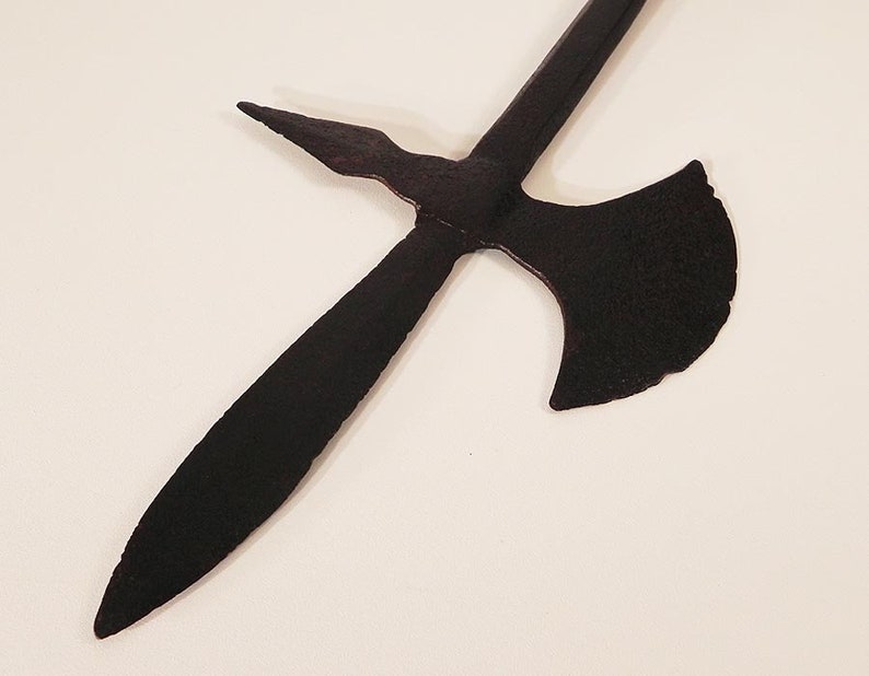 May include: A black metal weapon with a long, pointed blade and a curved axe head. The weapon is made of metal and has a rustic, aged appearance.