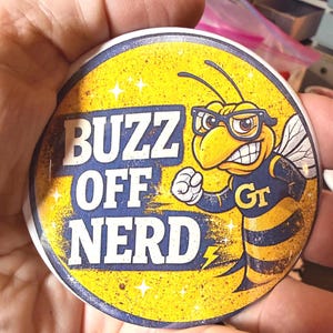 3 inch round button "Buzz Off Nerd" is the cutest! A fan favorite. Love the  look. Great for any event!