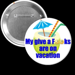 May include: A white button with a humorous message in blue text: "My give a F**ks are on vacation." The design includes a cartoon coconut drink with a blue umbrella and straws. The button has a metal pin back.