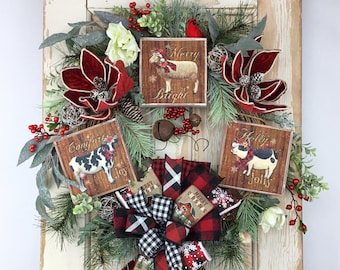 Könnte beinhalten: Ein Weihnachtskranz mit einer rot-schwarzen Karoband Schleife, geschmückt mit Grün, roten Beeren und weißen Blüten. Drei Holzschilder mit Bauernhoftieren und Weihnachtsgrüßen sind am Kranz befestigt: "Merry Bright", "Comfort & Joy" und "Holly Jolly".