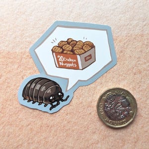 May include: A cartoon sticker featuring a pill bug and a thought bubble with a box of 20 chicken nuggets. A one-pound coin is next to the sticker. The pill bug is brown and black with small black legs and antennae.
