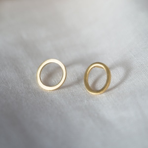 May include: A pair of gold-toned hoop earrings with a simple, circular design. The earrings are small and delicate, and they would make a great everyday accessory.