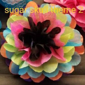 May include: A colorful, layered paper flower with a black center. The petals are a mix of pink, orange, yellow, green, and blue. The text "sugar skull theme 2" is visible in the upper left corner.