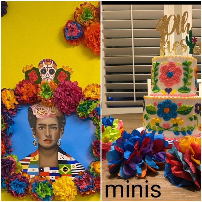 Pu&ograve; includere: Immagine vibrante con un ritratto di Frida Kahlo circondato da fiori di carta colorati e un teschio di zucchero. &Egrave; presente anche una torta a tre piani con decorazioni floreali e un topper "40th Fiesta", insieme ad altri fiori di carta. La parola "minis" &egrave; in basso.
