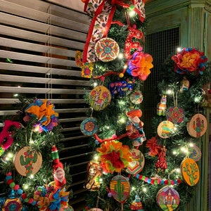 Pu&ograve; includere: Un albero di Natale decorato con ornamenti colorati, tra cui cactus, sombreros e disegni floreali. L'albero &egrave; adornato con luci a stringa e un grande fiocco rosso con un nastro fantasia. Il tema generale &egrave; una celebrazione vibrante.