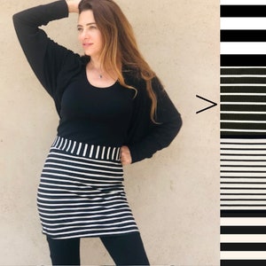 Pu&ograve; includere: Una gonna a righe bianche e nere con una maglia nera e leggings neri. La gonna ha una fascia elastica larga.
