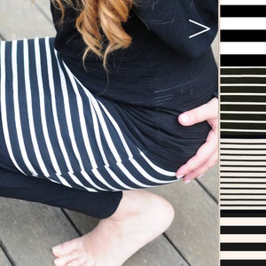 May include: A black and white striped skirt with a black top. The top has a small white arrow on the front.