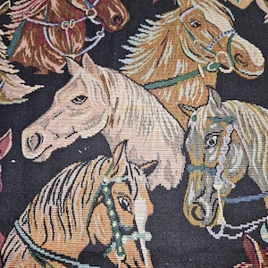 May include: Close-up of a woven fabric featuring multiple horse heads in various shades of brown, tan, and cream. The horses are adorned with bridles in blue, green, and brown, set against a black background. The textile has a tapestry-like appearance.
