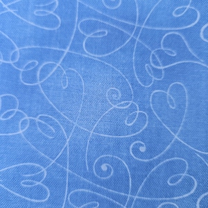 May include: A blue fabric with a white swirl pattern. The fabric has a textured surface.