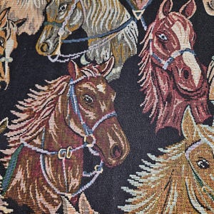 May include: Close-up of a woven fabric featuring multiple horse heads in various shades of brown, tan, and burgundy. The horses are adorned with bridles and harnesses against a black background. The textile has a tapestry-like appearance.