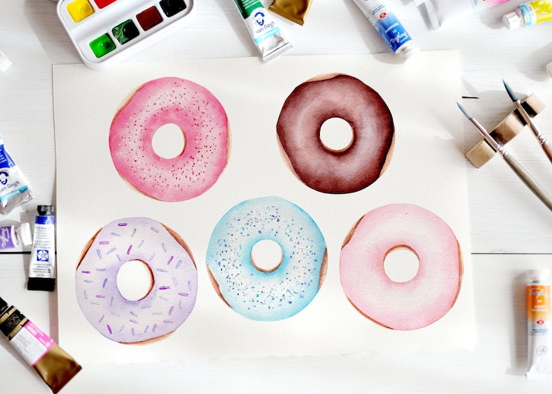 May include: Five watercolor donuts on a white background. The donuts are pink, brown, purple, blue, and light pink. Each donut has a different type of sprinkle on top.