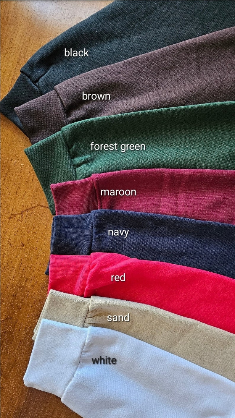 May include: A stack of eight fabric swatches in different colors, including black, brown, forest green, maroon, navy, red, sand, and white.
