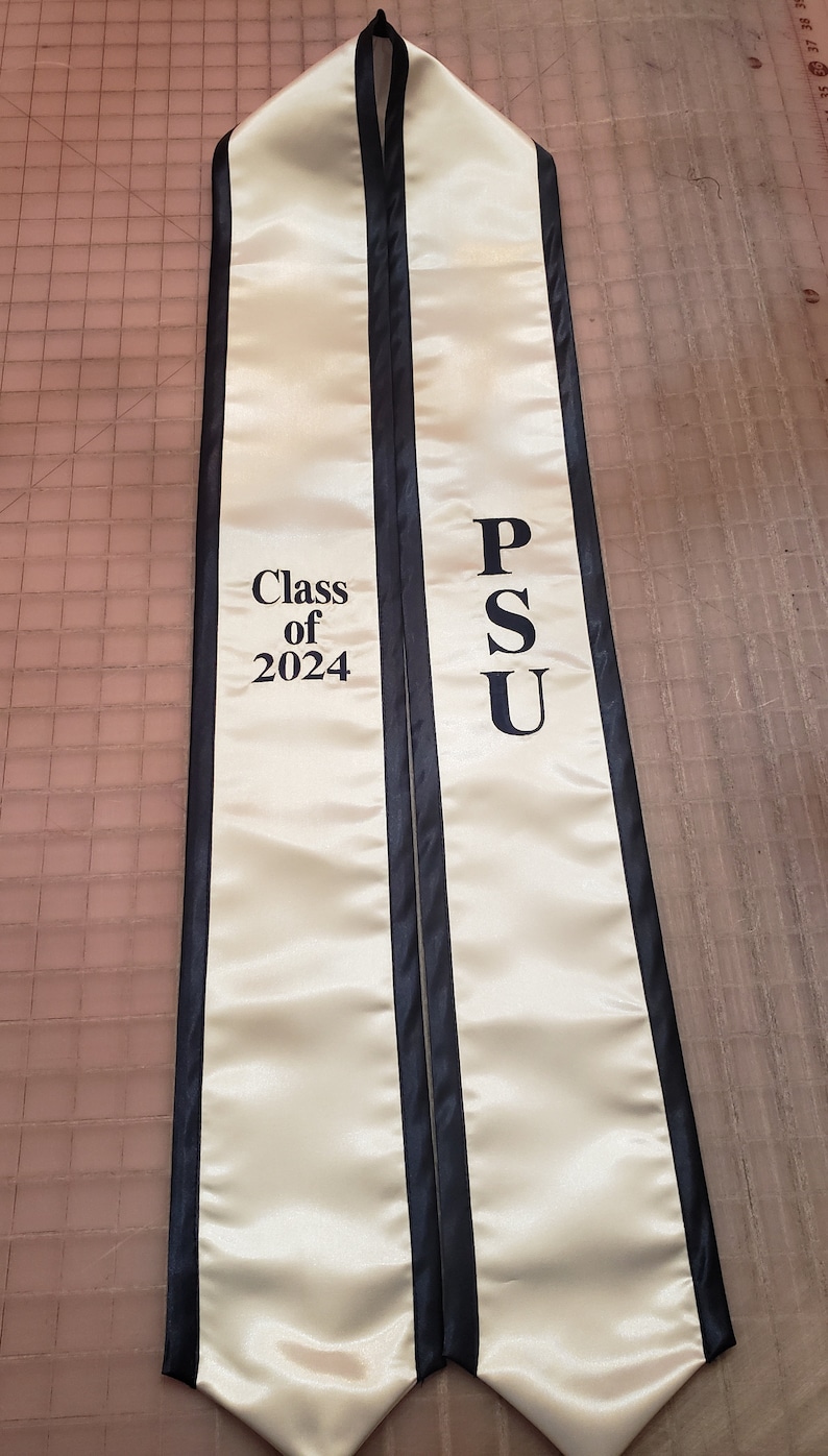 Może przedstawiać: Biała szarfa absolwentka z czarnym wykończeniem. Na szarfie widnieje napis "Class of 2024" po jednej stronie i "PSU" po drugiej.