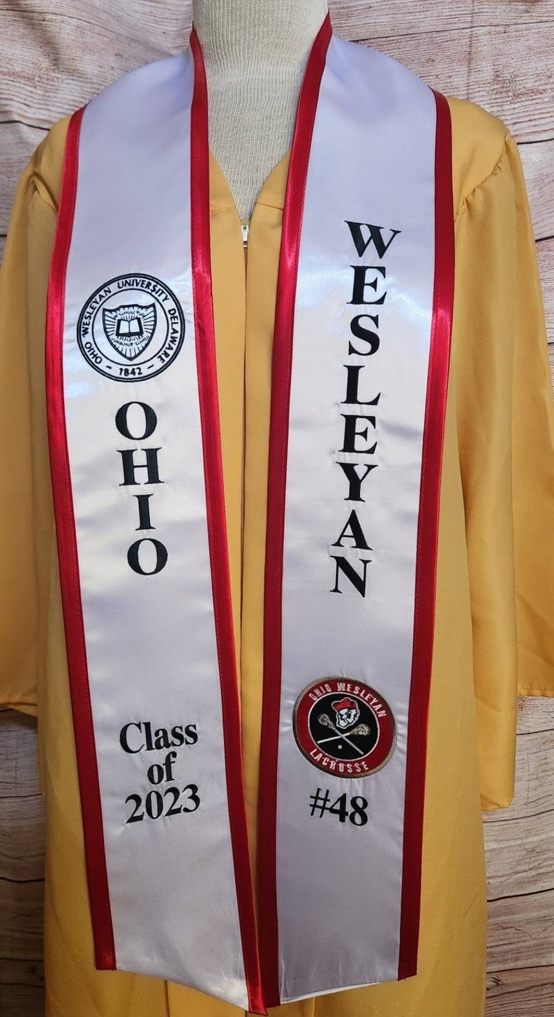 May include: White graduation sash with red trim, featuring the Ohio Wesleyan University logo, the text "OHIO WESLEYAN" and "Class of 2023", and a lacrosse player logo with the text "GRID WESLEYAN LACROSSE #48".