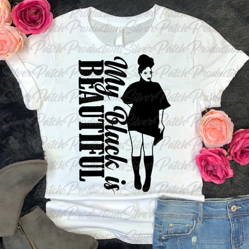 Puede incluir: Camiseta blanca con texto negro que dice "My Black is Beautiful" y una silueta de una mujer con afro.