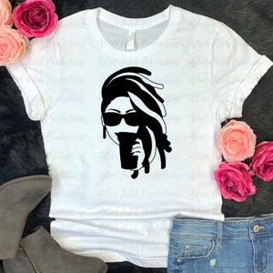 May include: A white t-shirt with a black silhouette of a woman with dreadlocks wearing sunglasses and holding a cup of coffee.