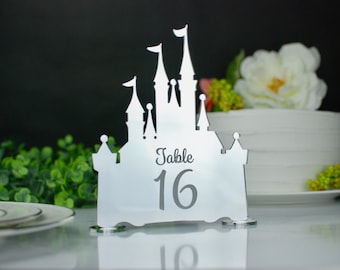 Può includere: Numero di tavolo in specchio argentato con una silhouette di castello. Il numero 16 è visualizzato sulla parte anteriore del castello. Il testo "Table" è sopra il numero.