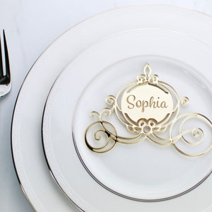 Op de afbeelding: Gouden glitter Assepoester koets plaatskaart met de naam Sophia erop.