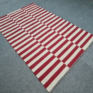 Red and white striped kilim rug, made of wool. It can be made in any size. popular sizes are: 8x10 rug, 4x6 rug, 9x12 rug, 5x7 rug, 5x8 rug, 6x8 rug, 6x9 rug. It can be made in other colors as well
