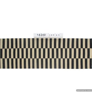 May include: A rectangular rug with a repeating pattern of black and beige vertical stripes. The rug has a woven texture and a label with the numbers "18260 300 83".