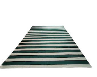 May include: A rectangular rug with alternating wide stripes of green and white. The rug has a simple, modern design, suitable for various interior styles. The rug's dimensions are not visible in the image.