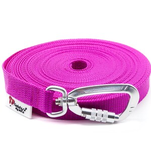 Puede incluir: Una correa retr&aacute;ctil para perros de color rosa con un mosquet&oacute;n plateado. La correa est&aacute; enrollada y la marca "Twinkle" es visible en la correa.