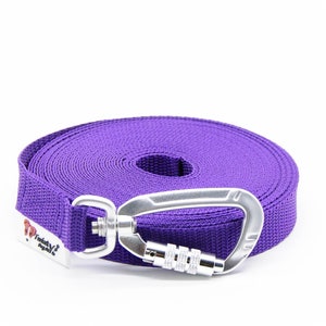Puede incluir: Correa retr&aacute;ctil para perro de color morado con un mosquet&oacute;n plateado. La correa est&aacute; enrollada y la marca "Totally Tails" es visible en la correa.