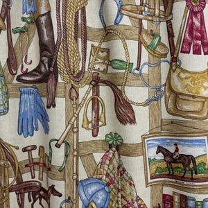 May include: Fabric with a repeating pattern of equestrian equipment, including riding boots, gloves, saddles, and ropes. The design features a color palette of brown, beige, blue, and green, with a framed image of a horse and rider.