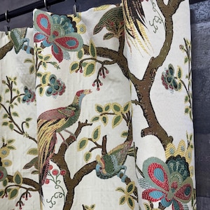 May include: White fabric curtain panel with a colorful embroidered design featuring birds, butterflies, and floral motifs. The design is in shades of red, blue, green, yellow, and brown.