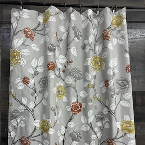 May include: Gray shower curtain with a floral pattern featuring white branches, gray, yellow, and red flowers.
