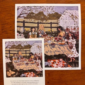 May include: Two art prints depicting a picnic scene with several people. The larger print shows a picnic table with food and people, and the smaller print shows a similar scene. Text at the bottom of the smaller print reads, "Above all, love each other deeply..."