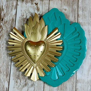 May include: A white ceramic mug with a black handle and the text "But First, Coffee" in a handwritten style. The mug is on a white surface. The mug is approximately 10 cm tall.