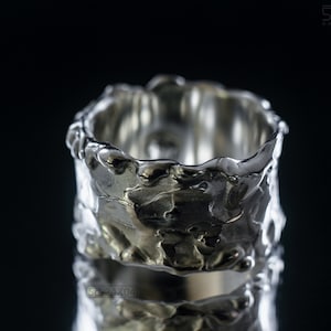 Molten Metal Chunky Ring, Dramatic Jewellery for Men and Women, Unisex Broad Ring with Irregular Edges. On Black Background with Mirror Reflection from Underneath.