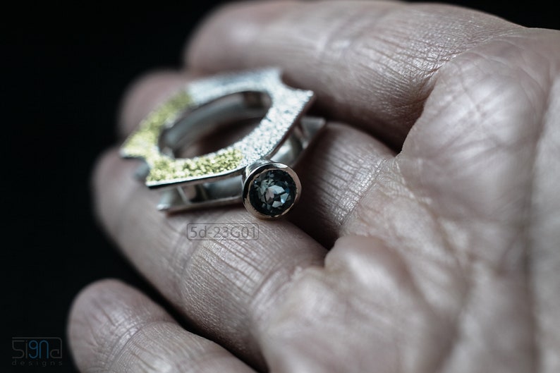 Contemporary ring with reticulated sterling silver and keum boo 24k gold foil and blue topaz stone, double-sided. In Hand.