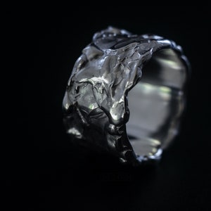 Molten Metal Chunky Ring, Dramatic Jewellery for Men and Women, Unisex Broad Ring with Irregular Edges. On Black Background.