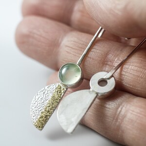 Reticulated Silver Earrings with 24k Keum-Boo Gold Foil and Prehnite Cabochons, Organic and Contemporary. Reticulated Half Oval Shape with a Stripe of Gold Leaf and Long Ear Wires. In hand. One with front, the other with the back view.