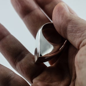 Geometric Ring, Contemporary Design, Massive, Bold and Unisex, with High Shine Finish. in hand. White background.