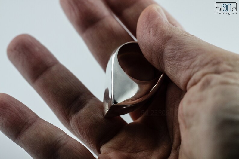 Geometric Ring, Contemporary Design, Massive, Bold and Unisex, with High Shine Finish. in hand. White background.