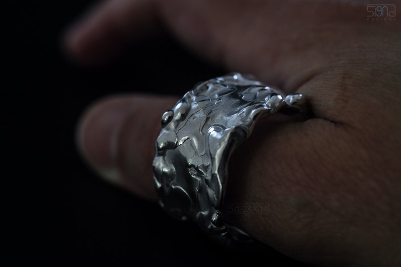 Molten Metal Chunky Ring, Dramatic Jewellery for Men and Women, Unisex Broad Ring with Irregular Edges. On Black Background, on Thumb.