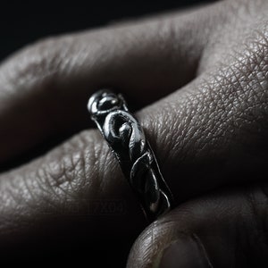 Primitive, raw, organic unisex sterling silver ring with twisted design and patina. On Finger.