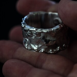 Molten Metal Chunky Ring, Dramatic Jewellery for Men and Women, Unisex Broad Ring with Irregular Edges. On Black Background in Hand.