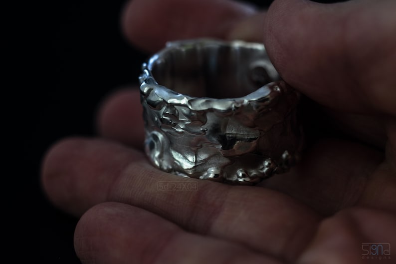 Molten Metal Chunky Ring, Dramatic Jewellery for Men and Women, Unisex Broad Ring with Irregular Edges. On Black Background in Hand.