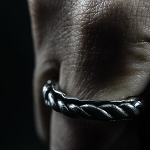 Primitive, raw, organic unisex sterling silver ring with twisted design and patina. On finger.