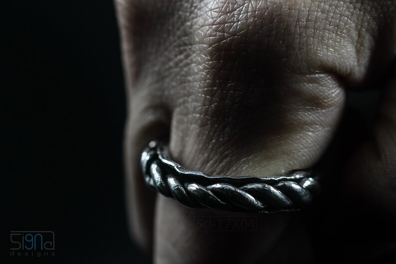 Primitive, raw, organic unisex sterling silver ring with twisted design and patina. On finger.